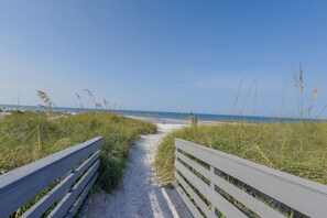 A sandy path leading to a beach with a wooden fence on either side. - Walk to Shore! PCB Condo w/ Pool & Hot Tub Access (Panama City Beach)