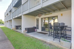 A building with a covered outdoor seating area, a trash bin, and a large storage unit. - Walk to Shore! PCB Condo w/ Pool & Hot Tub Access (Panama City Beach)