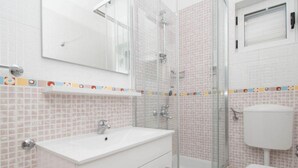 A bathroom with a white sink, a glass shower enclosure, and a toilet. - Apartments Antonio - Comfort One-bedroom Apartment With Balcony and Sea View - 4 (Tucepi)