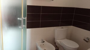 A bathroom with a bidet, toilet, and a glass partition. - Apartments Lux Lukić Utjeha - Triple Room (Utjeha)