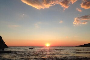 A sunset over the ocean with a boat in the distance. - Casa Mila Apartments - Studio apartment with sea view (Ulcinj)