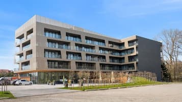 Ein mehrstöckiges Gebäude mit modernem architektonischen Design, das Balkone und große Fenster kombiniert.