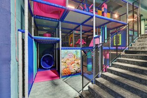 A multi-level play area with netted structures, a slide, and a staircase. - Grano Aparthotel Ustronie Morskie (Ustronie Morskie)