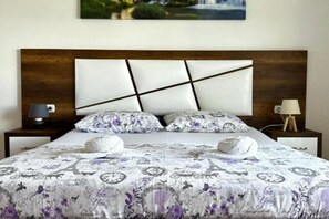 A bed with a patterned bedspread, two pillows, and a headboard with a geometric design. - Casa Mila Apartments - Studio apartment with sea view (Ulcinj)
