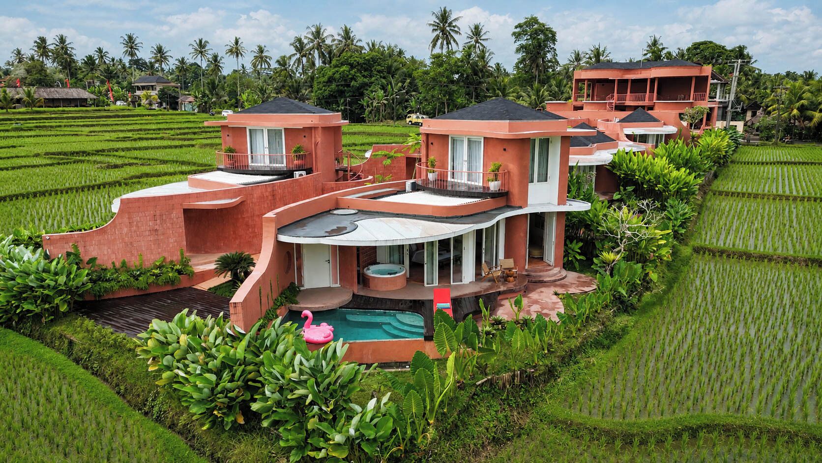 Una villa moderna con piscina, rodeada de exuberantes campos de arrozales y palmeras.