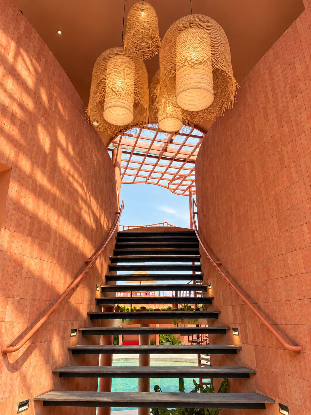 A staircase with a metal railing, leading to a pool area.
