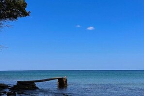 A calm sea with a clear sky and a wooden structure in the foreground. - Casa Mila Apartments - Standard Triple bedroom with sea view (Ulcinj)