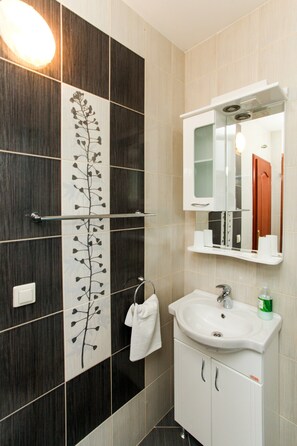 A bathroom with a white sink, a mirror, and a towel rack.