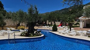 A swimming pool with a slide, surrounded by lounge chairs and cacti. - Villa Ponto - Studio Apartment With Terrace (B3) (Kaluderac)