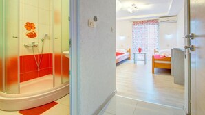 A hotel room with a shower, a bed, a bedside table, and a wardrobe. - Glory Sanctuary Retreat - Twin room with balcony 2 (Medugorje)