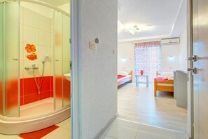A hotel room with a shower, a bed, a bedside table, and a wardrobe. - Glory Sanctuary Retreat - Twin room with balcony 2 (Medugorje)