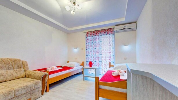 A hotel room with two single beds, a sofa, a desk, and an air conditioning unit. - Glory Sanctuary Retreat - Twin room with balcony 2 (Medugorje)