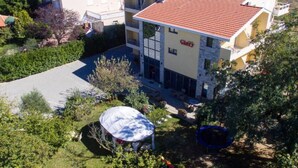 A multi-story building with a red-tiled roof, a covered outdoor area, and a swimming pool. - Glory Sanctuary Retreat - Twin room with balcony 2 (Medugorje)