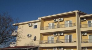 A multi-story building with balconies and air conditioning units.