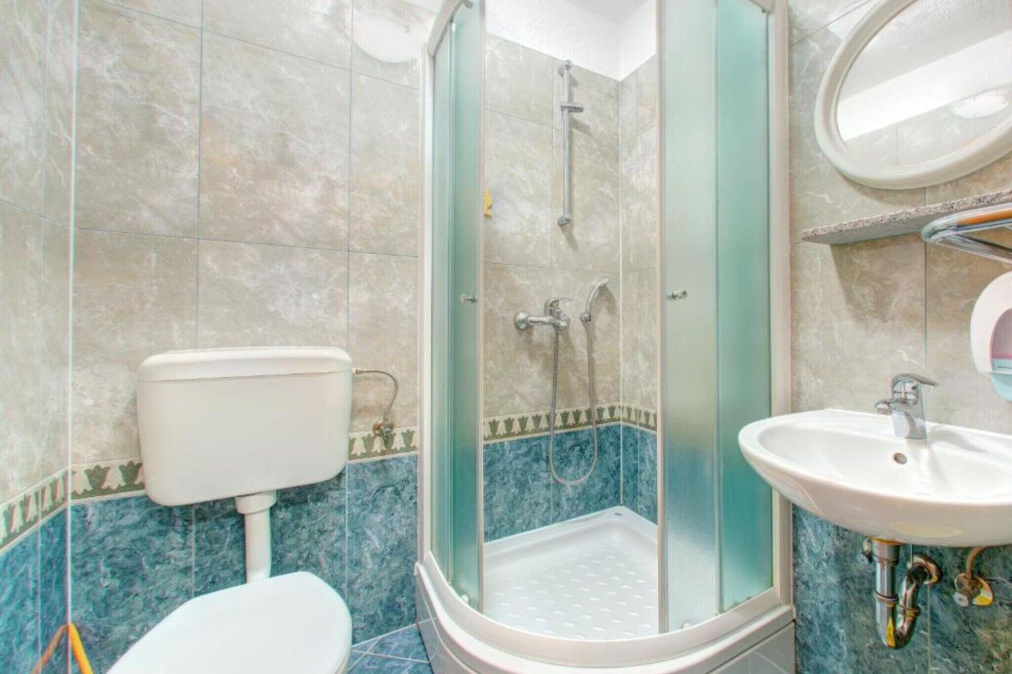 Une salle de bain avec une douche à parois de verre, des toilettes et un lavabo.