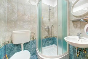 A bathroom with a glass-enclosed shower, a toilet, and a sink. - Glory Sanctuary Retreat - Triple Room with Balcony (Medugorje)