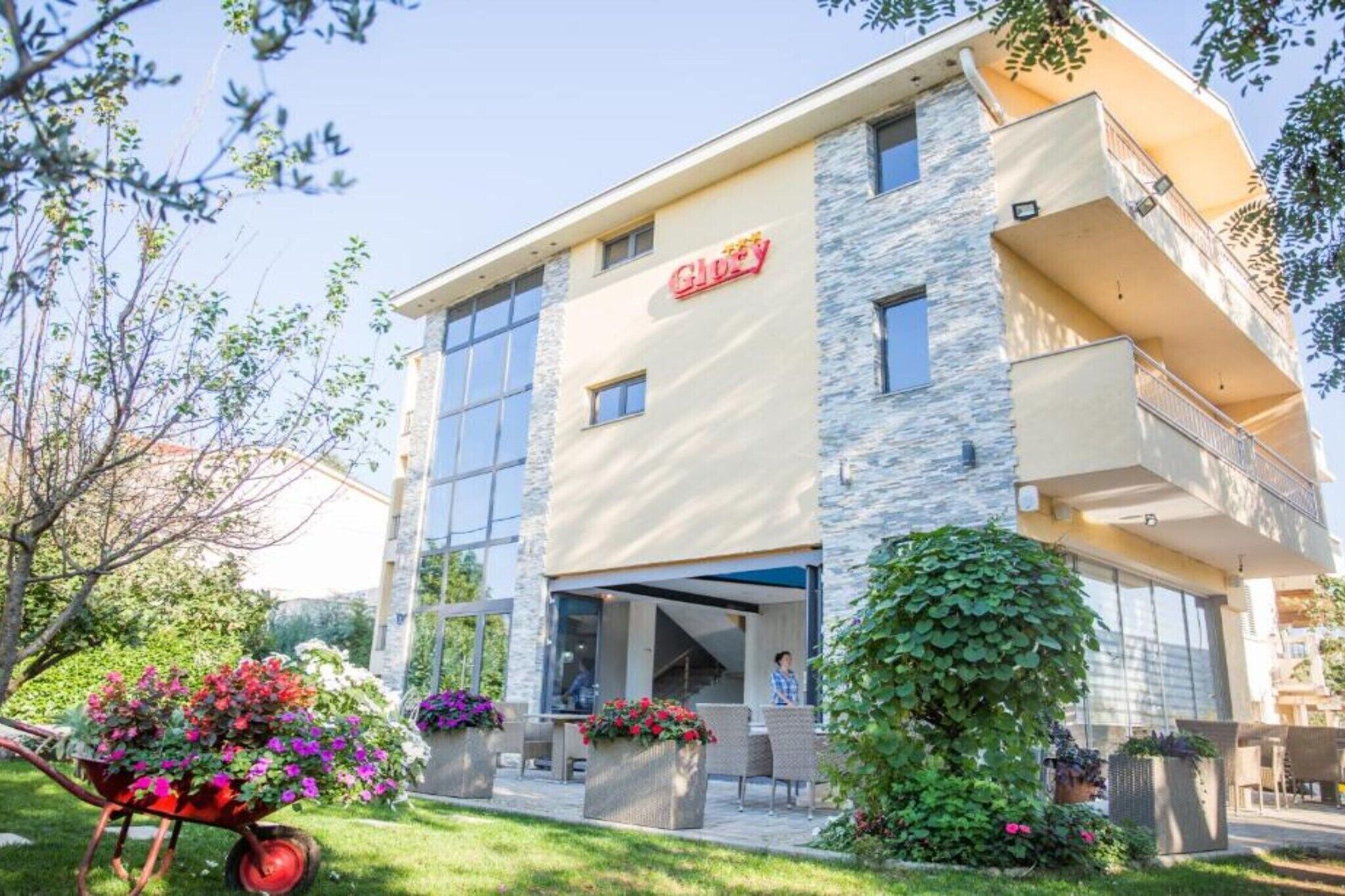 A modern hotel with a stone facade, large windows, and a covered entrance.
