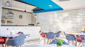 A modern restaurant interior with a bar area, dining tables, and chairs. - Glory Sanctuary Retreat - Family room (Medugorje)