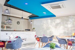 A modern restaurant interior with a bar area, dining tables, and chairs. - Glory Sanctuary Retreat - Family room (Medugorje)