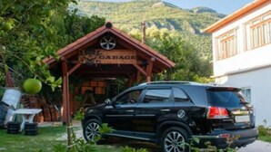 Un SUV negro estacionado frente a un garaje de madera con un letrero.