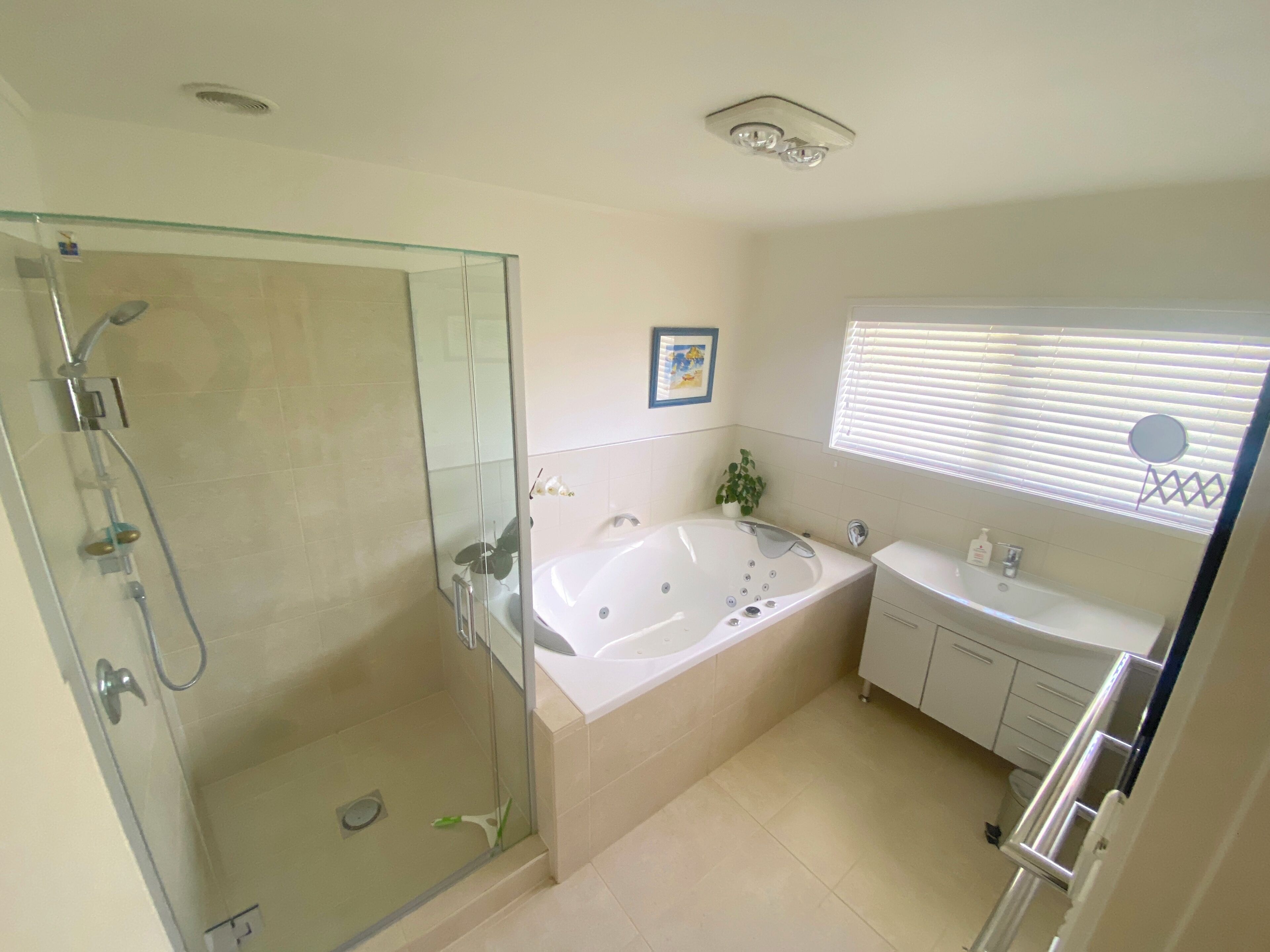 Une salle de bain dotée d’une douche à parois de verre, d’une baignoire sur pieds et d’un meuble-lavabo avec un évier.
