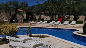 Ein Poolbereich mit Liegestühlen und einer Rutsche.