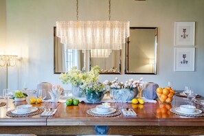 A dining table set with glassware, plates, and a centerpiece of flowers and fruits. - Refined 3-Bedrooms Apartment In Palazzo Busdraghi (Lucca)