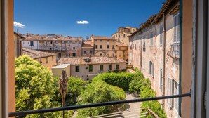 Une vue d’une ville historique, avec ses bâtiments traditionnels, un balcon et une végétation luxuriante.