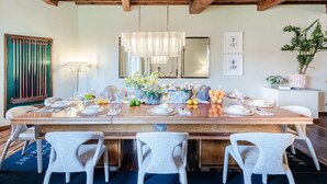Un coin repas avec une table en bois dressée pour six personnes, entourée de six chaises.