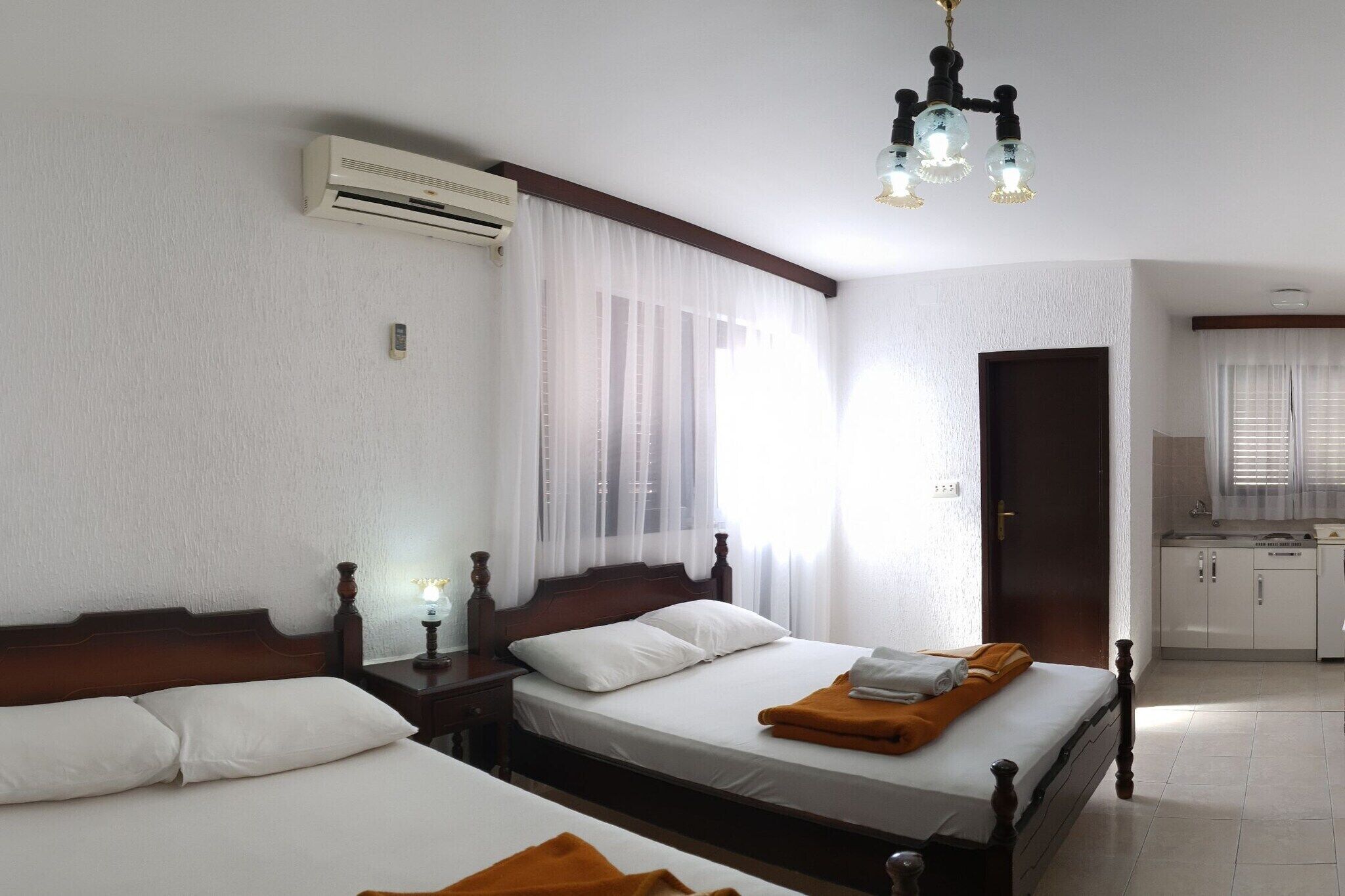Ein Hotelzimmer mit zwei Betten, einer Küchenzeile und einem Badezimmer.