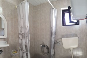 Ein Badezimmer mit Dusche, Toilette und Waschbecken.