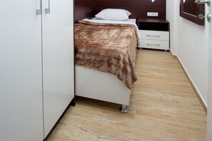 A bedroom with a bed, a bedside table, a nightstand, and a wardrobe. - Guest House 4M Gregović - Three bedroom apartment (Petrovac na Moru)