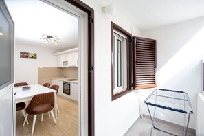 Eine kompakte Küche mit Essbereich, einem eingebauten Ofen und einem Fenster mit Holzläden.