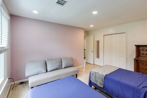 A bedroom with two beds, a bench, and a dresser. - Easy Transit to DC! Family Home w/ Fenced Yard (Springdale)