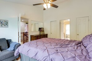 A bedroom with a bed, a ceiling fan, a dresser, and a door leading to another room. - Easy Transit to DC! Family Home w/ Fenced Yard (Springdale)