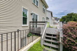 A residential property with a wooden deck, a brick foundation, and a metal fence. - Easy Transit to DC! Family Home w/ Fenced Yard (Springdale)