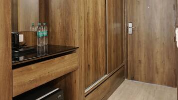 Una habitación con paneles de madera, una kitchenette, un espejo y una puerta.