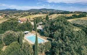 A villa with a swimming pool surrounded by trees, set in a hilly landscape. - Lovely home in Cinigiano (Cinigiano)