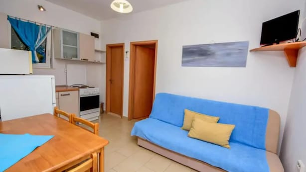 A compact living space with a kitchenette, a sofa, a dining table, and a television. - Coastal Breeze House - House (Selca)