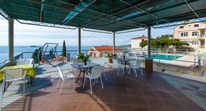 A covered outdoor area with a pool, seating, and a view of the sea. - Apartments Klis -studio Apartment With Terrace - 2 (Zupa dubrovacka)