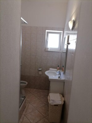 A small bathroom with a toilet, sink, and shower. - Apartments Libertas - Two Bedroom Apartment With Balcony and Sea View - (Rogoznica)
