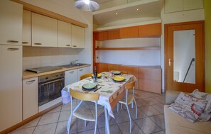 Una cucina compatta con zona pranzo, forno integrato e lavello.