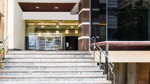 A staircase leading to a building entrance with glass doors and a sign above. - Super Collection O Madhapur (Hyderabad)