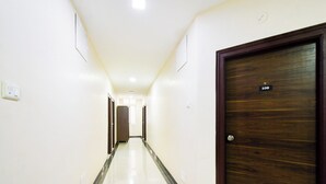 A hotel corridor with a wooden door marked '108' and a white tiled floor. - Super Collection O Madhapur (Hyderabad)