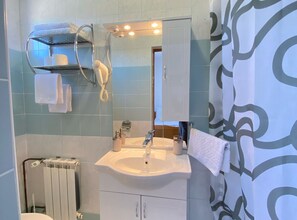 A bathroom with a white sink, a towel rack, a hairdryer, and a radiator. - Standard Twin 2 (Rakovica)