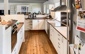 A modern kitchen with white cabinetry, a wooden countertop, and a stainless steel refrigerator. - 4 bedroom gorgeous home in Lemvig (Lemvig)