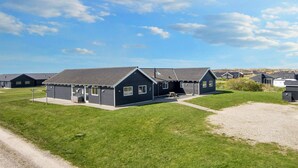 A row of dark-colored, single-story buildings with a flat roof, arranged in a linear fashion. - Pet friendly home in Harboøre with sauna (Harboøre)
