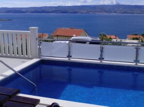A pool with a view of the sea and distant hills. - Apartmani Cihorich - One Bedroom Apartment (Dugi Rat)