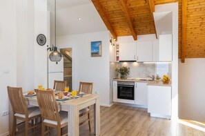A modern kitchen with white cabinets, a built-in oven, and a wooden ceiling. - Apartment M&K - Two Bedroom Apartment With Balcony and Sea View (Zupa dubrovacka)