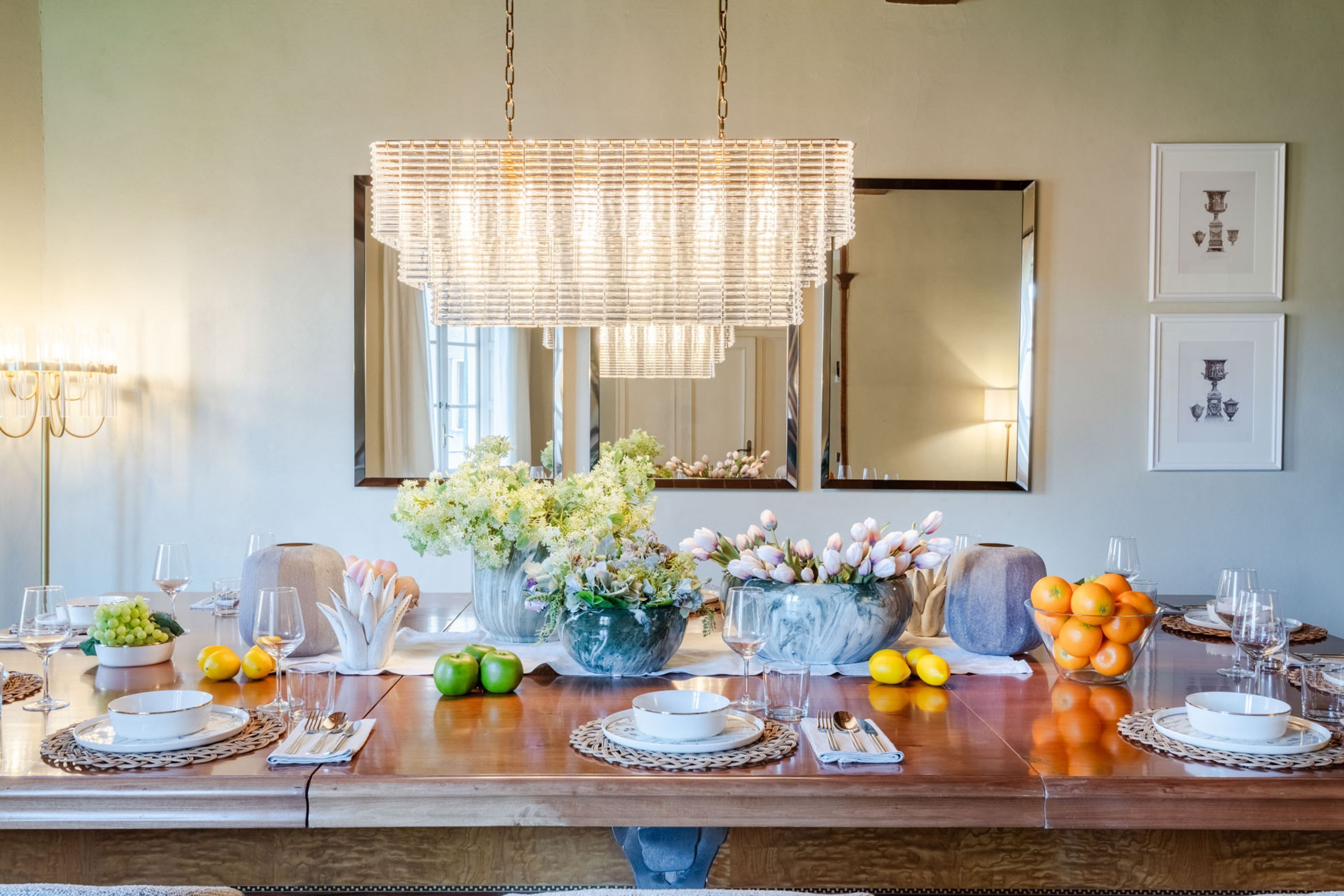 A dining table set for a meal with various dishes, glasses, and a centerpiece of flowers.